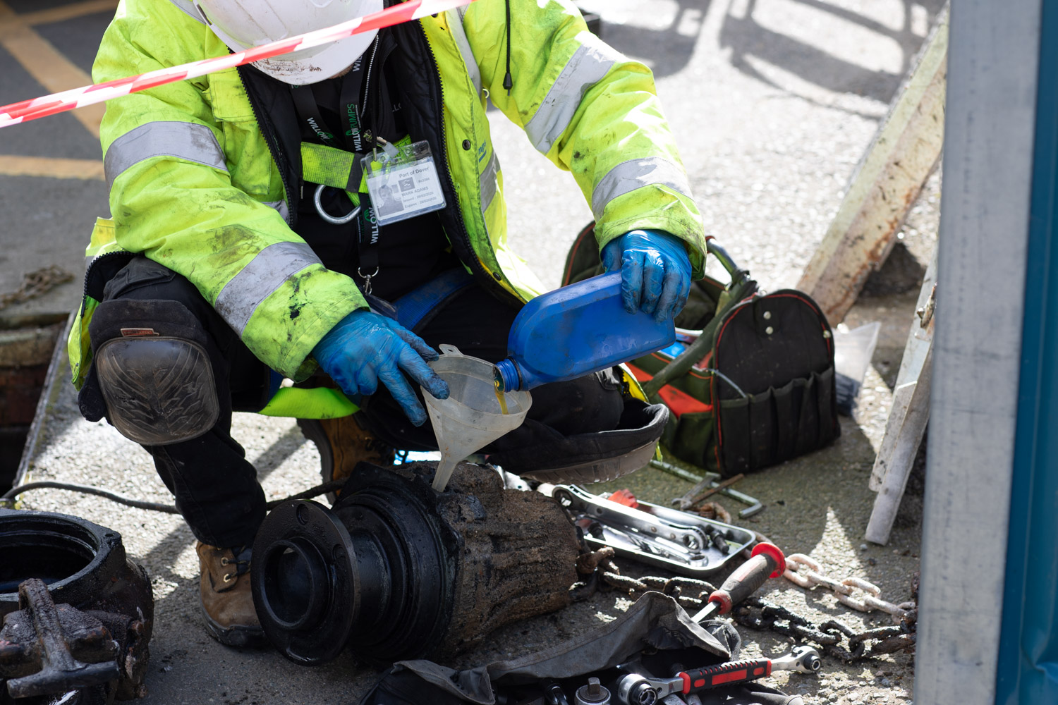 A Willow Pumps engineer adding oil to a sewage pump to maintain it and ensure it keeps working properly